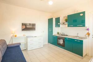 a kitchen with green cabinets and a blue couch at Giglio Rosa 4 n9 in Campese