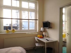 1 dormitorio con 1 cama, escritorio y 2 ventanas en Loft 76, en Bremen