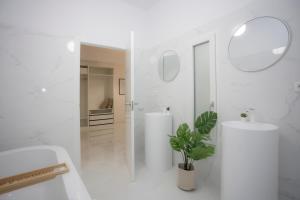 a white bathroom with a sink and a mirror at SingularStays Tinglado in Valencia