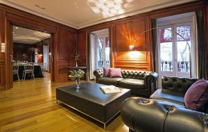 a living room with leather furniture and a table at Hospes Puerta de Alcalá, a Member of Design Hotels in Madrid