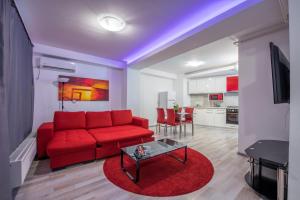 a living room with a red couch and a table at Bucharest Central Apartments - Shabbat Friendly in Bucharest