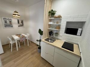 a small kitchen with a sink and a table at La Maison Appartement - a 200m dal Porto in Civitavecchia