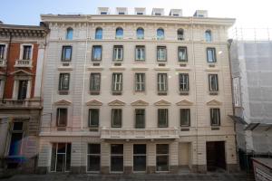 Un grand bâtiment blanc avec de nombreuses fenêtres dans l'établissement Be Mate Torino Centro, à Turin