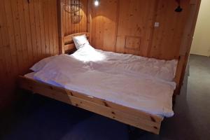 a bed in a wooden room with white sheets at Studio in Front De Neige Charvet Arc 1800 in Arc 1800