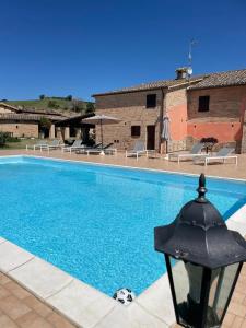 a swimming pool in front of a building at Agriturismo Villa Rosetta in San Severino Marche