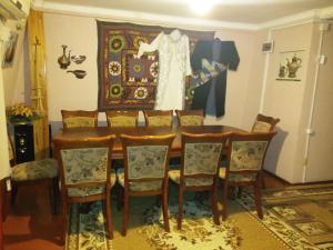 a dining room table with chairs and a dress hanging on a wall at Sayfi Guesthouse in Dushanbe