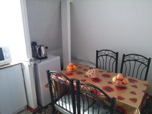 a table with two chairs and a table with fruit on it at Sayfi Guesthouse in Dushanbe