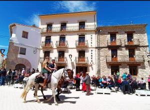 un grupo de personas montando caballos delante de un edificio en Hotel D` Ares, en Ares del Maestre