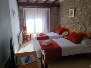 a hotel room with two beds and a window at Hotel D` Ares in Ares del Maestre