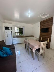 a kitchen and dining room with a table and a couch at Residencial Vista Bela in Bombinhas