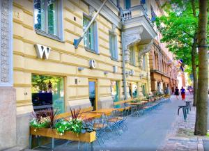 una fila de mesas y sillas fuera de un edificio en Scandinavian Home 15 in Heard City, en Helsinki