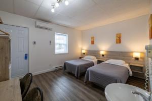 Una cama o camas en una habitación de Motel Et Condo Chez Charley