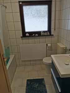 a bathroom with a sink and a toilet and a window at Ferienhaus Lichtenberg in Herleshausen