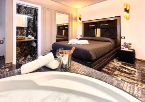 ein Hotelzimmer mit einem Bett und einer Badewanne in der Unterkunft Black Suite Hydro in Montecatini Terme