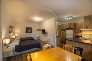 a bedroom with a bed and a kitchen with a table at Motel Et Condo Chez Charley in Sainte-Anne-de-Beaupré