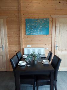 een eettafel met stoelen en een zwarte tafel met wijnglazen bij Vakantiehuisje vlakbij Leeuwarden, Swichumer Pleats in Swichum