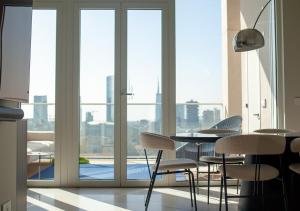 Habitación con mesa, sillas y ventana en Luxury apartment Milan - Skyline 16th floor, en Milán