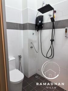 baño con ducha con una cámara en la pared en Ramadhan Villa PD, en Port Dickson