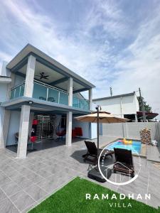 uma casa com um pátio e uma piscina em Ramadhan Villa PD em Porto Dickson