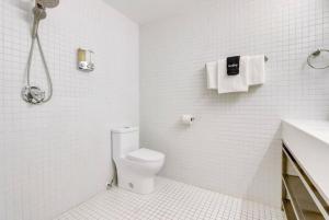 y baño blanco con aseo y ducha. en KCM Tremont Oaks Apartments 2, en Cleveland
