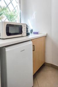 um micro-ondas em cima de um frigorífico numa cozinha em A23 - Monolocale in Ancona Centro sx em Ancona