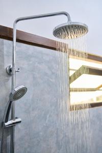 a shower with a shower head in a bathroom at Daasa Guest Mirissa in Mirissa