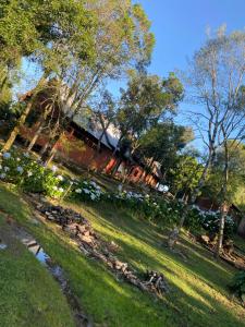 ein Zug, der durch einen Park mit Bäumen und Gras fährt in der Unterkunft Casa de campo próximo a Gramado in Três Coroas