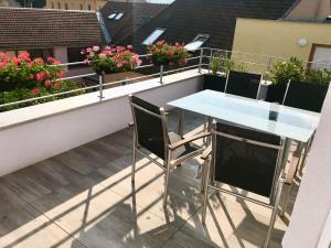 a table and chairs on a balcony with flowers at Ubytování Brno in Brno