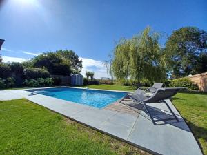 a chair sitting next to a swimming pool at La source de notre Manon 