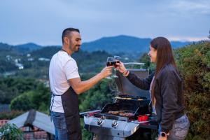 Ein Mann und eine Frau, die auf einem Grill kocht in der Unterkunft Finca Villa Isanella, Santuario, Antioquia in Santuario