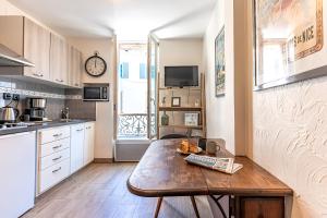 a kitchen with a wooden table in a room at FRGK " Charming Studio in Historic Center of Cannes" in Cannes
