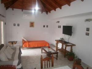 ein Wohnzimmer mit Sofa und Fernseher in der Unterkunft Vacaciones en Belgrano IG in Villa General Belgrano