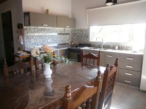 una cocina con una mesa con un jarrón de flores. en Vacaciones en Belgrano IG en Villa General Belgrano