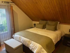 ein Schlafzimmer mit einem großen Bett und einer Holzdecke in der Unterkunft Quintinha da Bé, Ourém, Portugal in Ourém