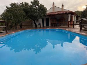 a large blue swimming pool in front of a house at Quintinha da Bé, Ourém, Portugal in Ourém