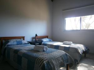 ein Schlafzimmer mit zwei Betten mit Handtüchern darauf in der Unterkunft Vacaciones en Belgrano IG in Villa General Belgrano
