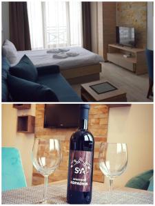 uma garrafa de vinho sentada numa mesa com dois copos de vinho em Apartment S&A Milmari Resort S43 em Kopaonik mais 45 fotografias