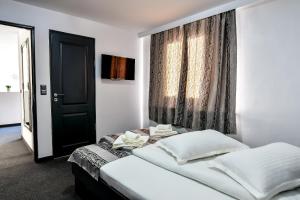 a bedroom with a bed with a black door and a window at Casa Mara in Ocna Şugatag