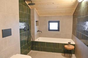 a bathroom with a tub and a toilet and a sink at Marand Boutique Apartments in Bansko
