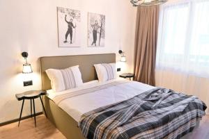 a bedroom with a bed and two posters on the wall at Marand Boutique Apartments in Bansko