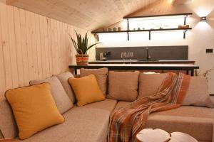 a couch with pillows in a room with a kitchen at Marand Boutique Apartments in Bansko