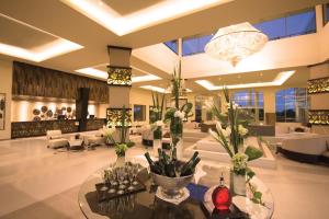um lobby com muita mobília e um lustre em El Dorado Seaside Suites Catamarán, Cenote & More Inclusive em Akumal