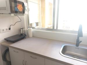 encimera de cocina con fregadero y ventana en Apartamentos céntricos a 10 min de la playa, en Almería