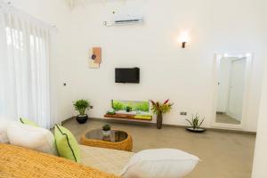 a living room with a couch and a tv at The Dahlia Residence in Bentota