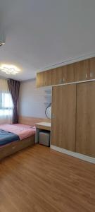 1 dormitorio con 1 cama, escritorio y armarios en CĂN HỘ CAO CẤP CÓ HỒ BƠI TẠI BIÊN HÒA, en Bien Hoa