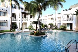 una piscina frente a un edificio con palmeras en Tamarindo Dominicus by Mireya, en La Laguna