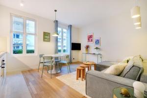 a living room with a couch and a table at Elegant Apartment in Boulogne-Billancourt