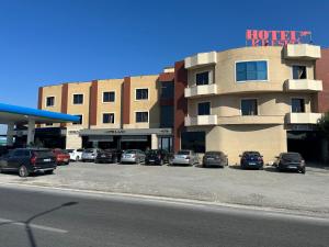 a hotel parking lot with cars parked in front of a building at Hotel Kresko in Lushnjë