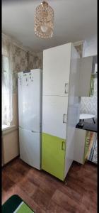 a kitchen with a white refrigerator and a chandelier at 3 комнатная, айбергенова in Shymkent