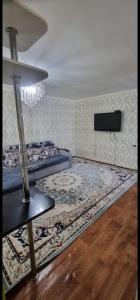 a room with two beds and a rug on the floor at 3 комнатная, айбергенова in Shymkent